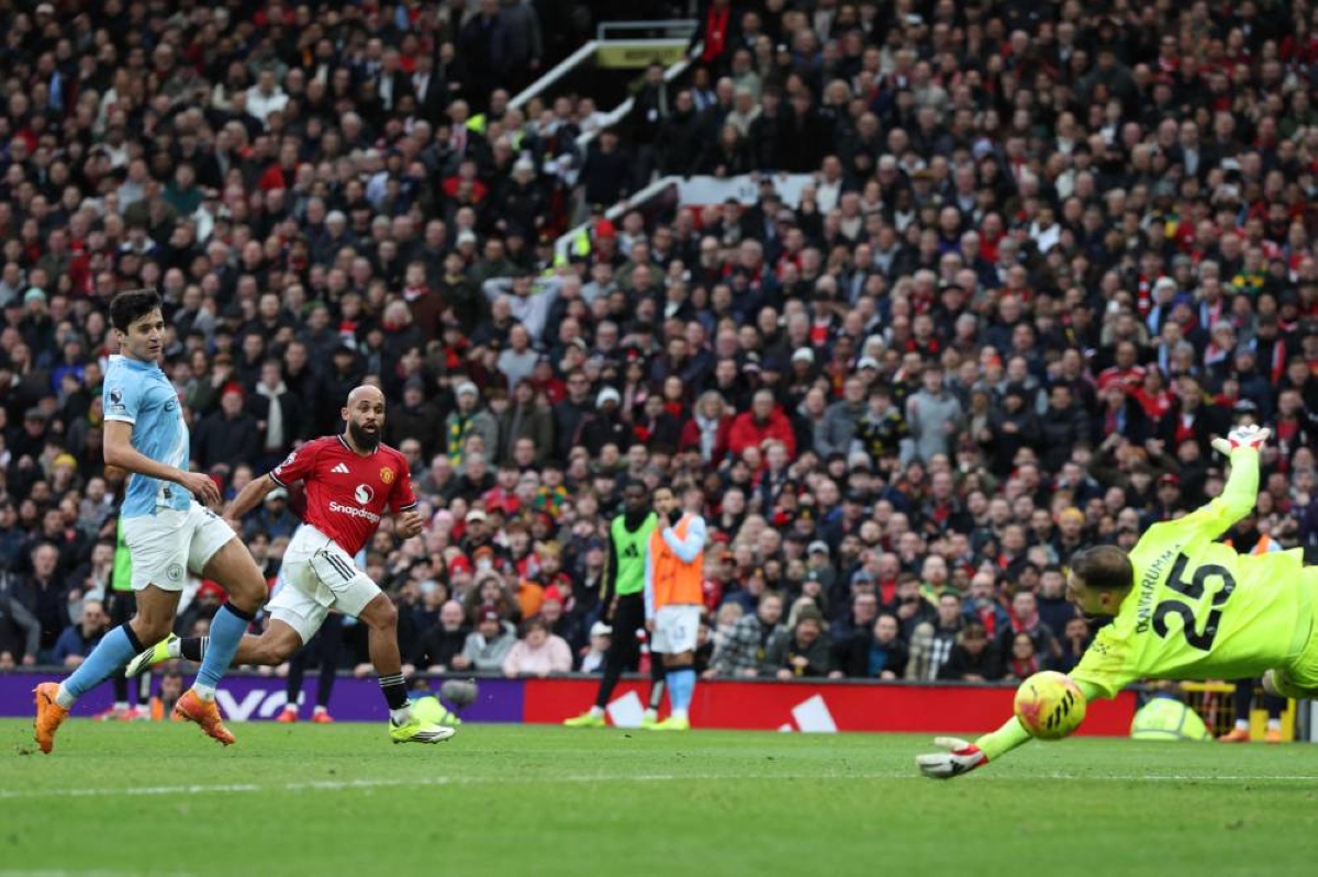 Manchester United's Cameroonian midfielder #19 Bryan Mbeumo (2L) shoots past Manchester City's Italian goalkeeper #25 Gianluigi Donnarumma to score the opening goal during the English Premier League football match between Manchester United and Manchester City at Old Trafford in Manchester, north west England, on January 17, 2026. (AFP) 