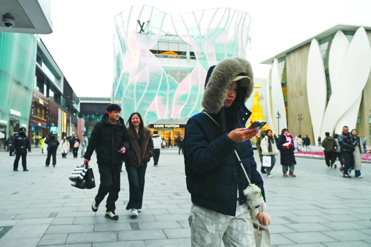 People visit a business district in Beijing on Sunday. The 5% expansion was in line with Beijing's annual target — a low-ball figure analysts have likened to a political comfort blanket. But observers warned it was driven largely by exports and masked weak sentiment on the ground.