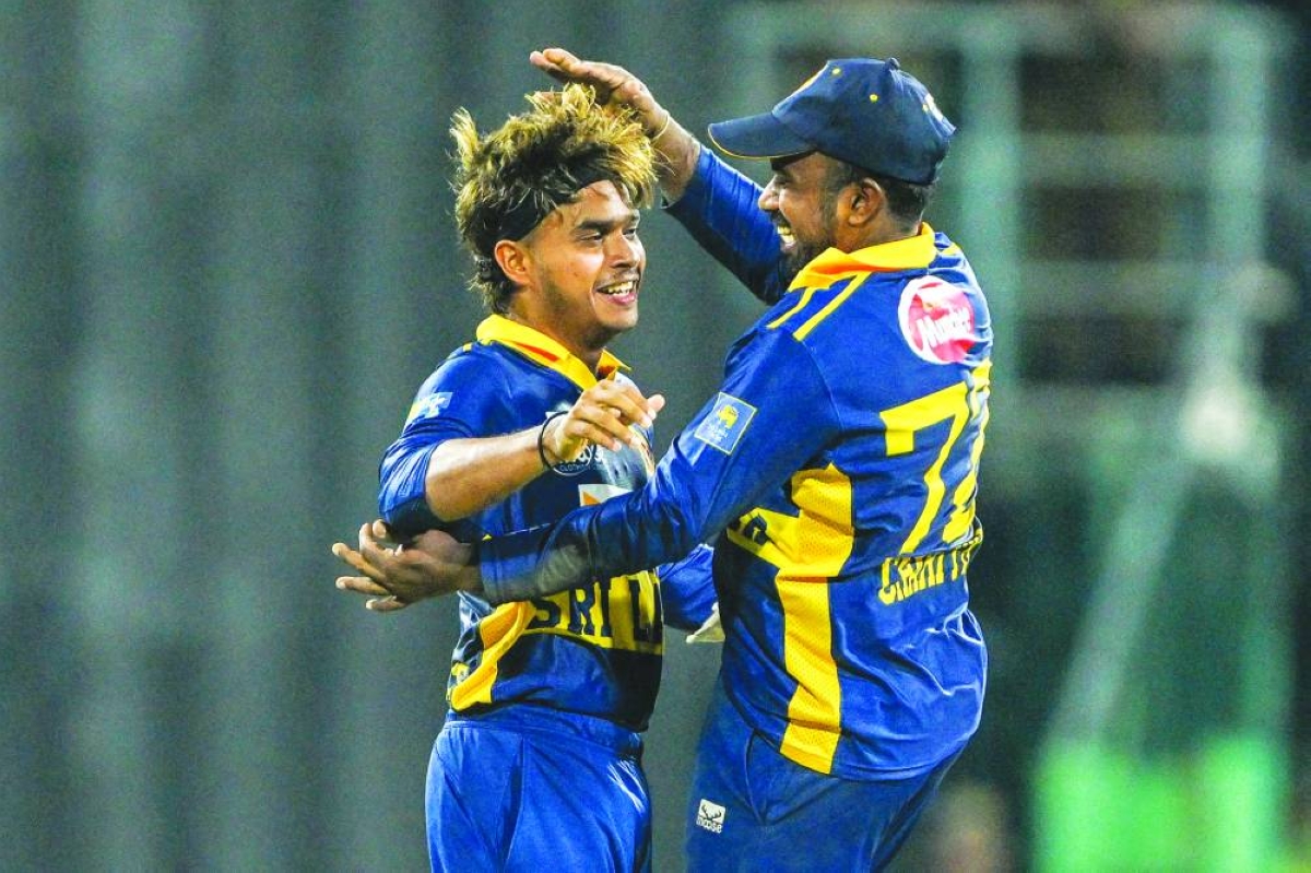 Sri Lanka's Dunith Wellalage (L) celebrates with captain Charith Asalanka after taking the wicket of England's Jacob Bethell during the first one-day international (ODI) cricket match between Sri Lanka and England at the R. Premadasa International Cricket Stadium in Colombo on January 22, 2026. (AFP)