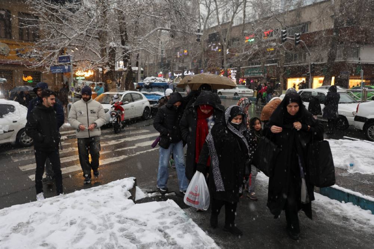 People cross a road during snowfall in Tehran, Iran, January 23, 2026. Majid Asgaripour/WANA (West Asia News Agency) via REUTERS ATTENTION EDITORS - THIS PICTURE WAS PROVIDED BY A THIRD PARTY