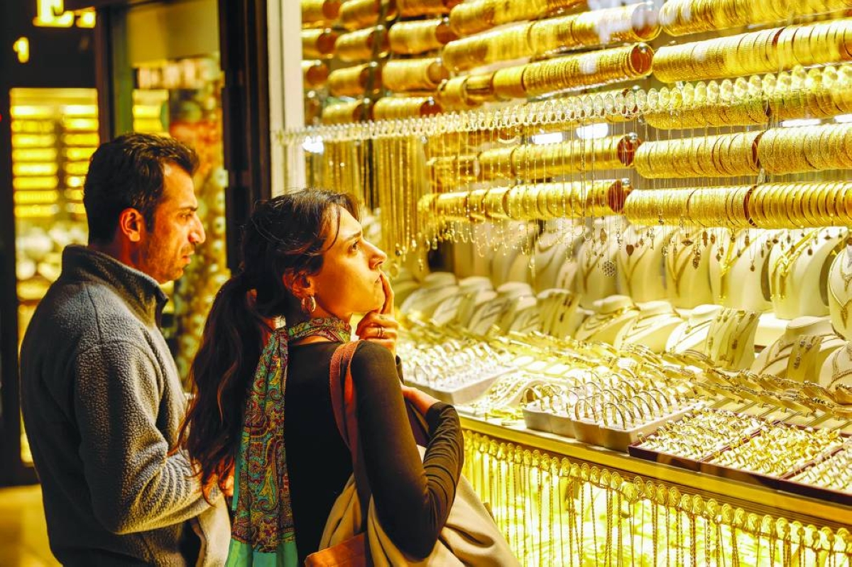 People look at gold jewellery as they stand outside a shop at the Grand Bazaar in Istanbul on Monday. Gold climbed above $5,100 an ounce, having cracked $5,000 on Sunday, amid rising global uncertainty and turmoil set off by US President Donald Trump's policies.