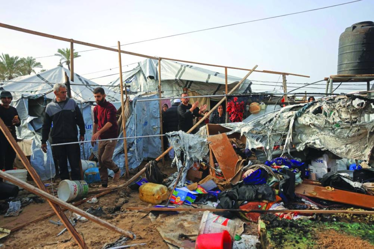 People inspect one of the tents, housing displaced Palestinians in the Mawasi area of Khan Yunis, in southern Gaza Strip, following Israeli strikes. 
