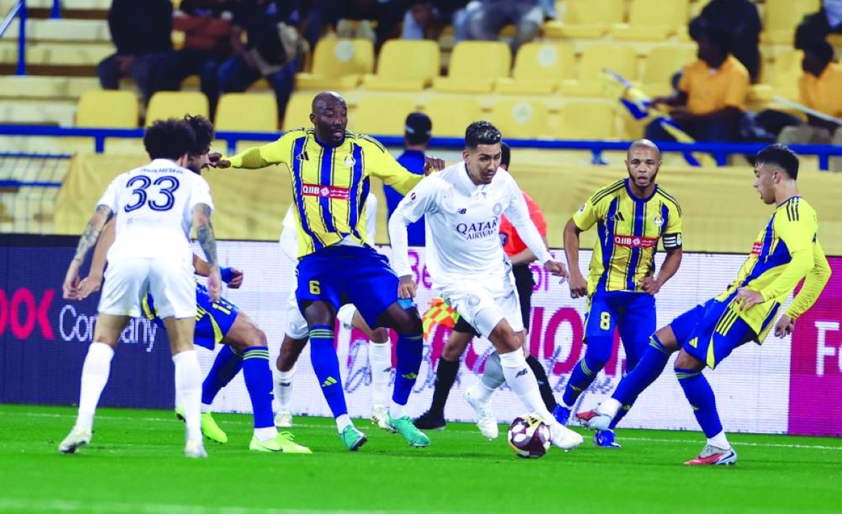 Al Sadd's Firmino attempts to dribble past Al Gharafa players at the Thani Bin Jassim Stadium.