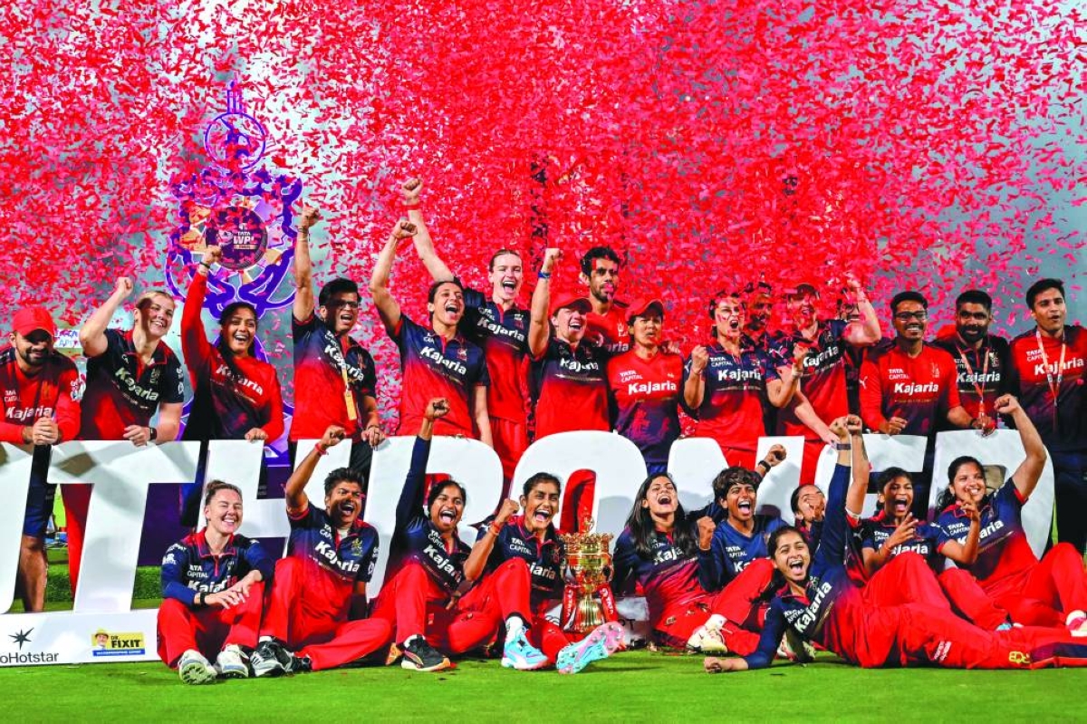 Royal Challengers Bengaluru's players celebrate with the trophy after winning the Women's Premier League final against Delhi Capitals at the Kotambi Stadium in Vadodara Thursday. (AFP)