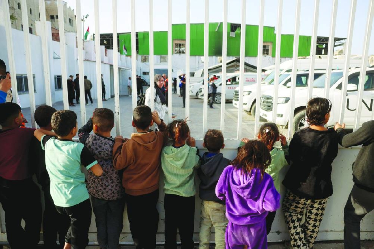 Children watch as war-wounded Palestinians and other patients prepare to leave the Gaza Strip for treatment through the Rafah border crossing between the Gaza Strip and Egypt after it was opened by Israel for a limited number of people. – AFP