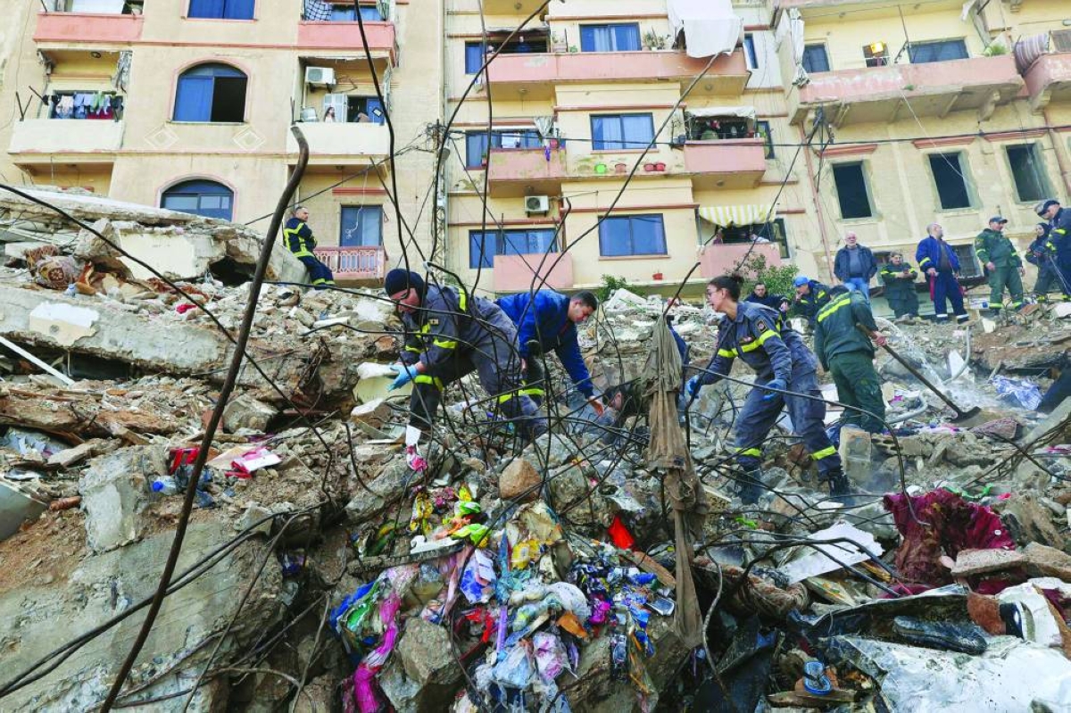 Lebanese civil defense and rescue workers search for survivors on February 9, 2026, in the rubble of an old residential building that collapsed in the Bab al-Tabbaneh neighborhood of Tripoli a day earlier. The death toll in a building collapse in the northern Lebanese city of Tripoli rose to 14 after search and rescue operations ended, the civil defence chief said on February 9. (AFP)