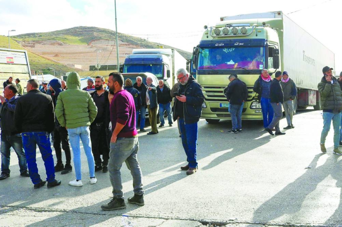 Lebanese truck drivers block the road on the Lebanese side of the Masnaa border crossing in protest against Syria’s decision to ban non-Syrian trucks from entering its territory, Tuesday.