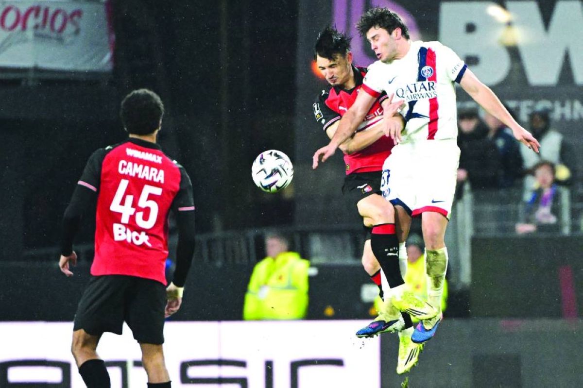 Rennes' French forward #09 Esteban Lepaul (C) and Paris Saint-Germain's Portuguese midfielder #87 Joao Neves fight for the ball during the French L1 football match between Stade Rennais FC and Paris Saint-Germain (PSG) at the Roazhon Park stadium in Rennes, western France, on February 13, 2026. (Photo by Damien MEYER / AFP)