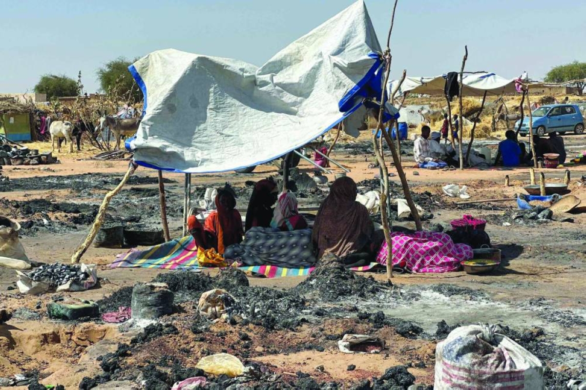 File photo shows displaced Sudanese people who left El-Fasher after its fall, sitting in the shade in Tawila amid the remains of a fire that broke out in the camp.