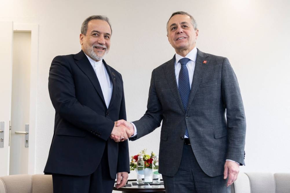 Switzerland's Foreign Minister Ignazio Cassis (R) shakes hands with Iran's Foreign Minister Abbas Araghchi during a bilateral meeting between Switzerland and Iran, in Geneva, Switzerland on February 17, 2026. (Photo by CYRIL ZINGARO / POOL / AFP)
