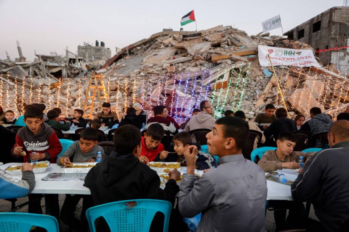 Palestinians gather for a mass fast-breaking Iftar meal organised by the Turkish IHH Foundation, amid the rubble of destroyed buildings in Gaza City, Wednesday.