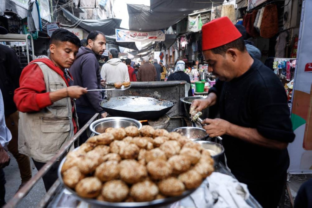 Palestinian street vendors make falafels in Gaza City's Zawiya market, Wednesday, on the first day of the holy fasting month of Ramadan.