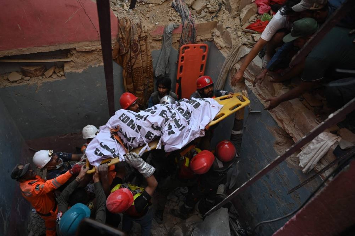 Rescue workers recover a victim’s body amid the debris of a collapsed building following an explosion, in Karachi on February 19, 2026. (Photo by Rizwan TABASSUM / AFP)