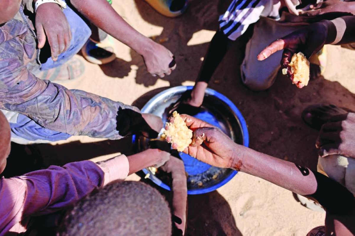 This picture taken in November last year shows orphaned Sudanese refugee children from El-Fashir sharing a meal of pasta and meat provided by the ‘Group Kitchen Project’, inside the Tine transit camp in eastern Chad, as they flee ongoing clashes between the paramilitary Rapid Support Forces (RSF) and the Sudanese army. – Reuters
