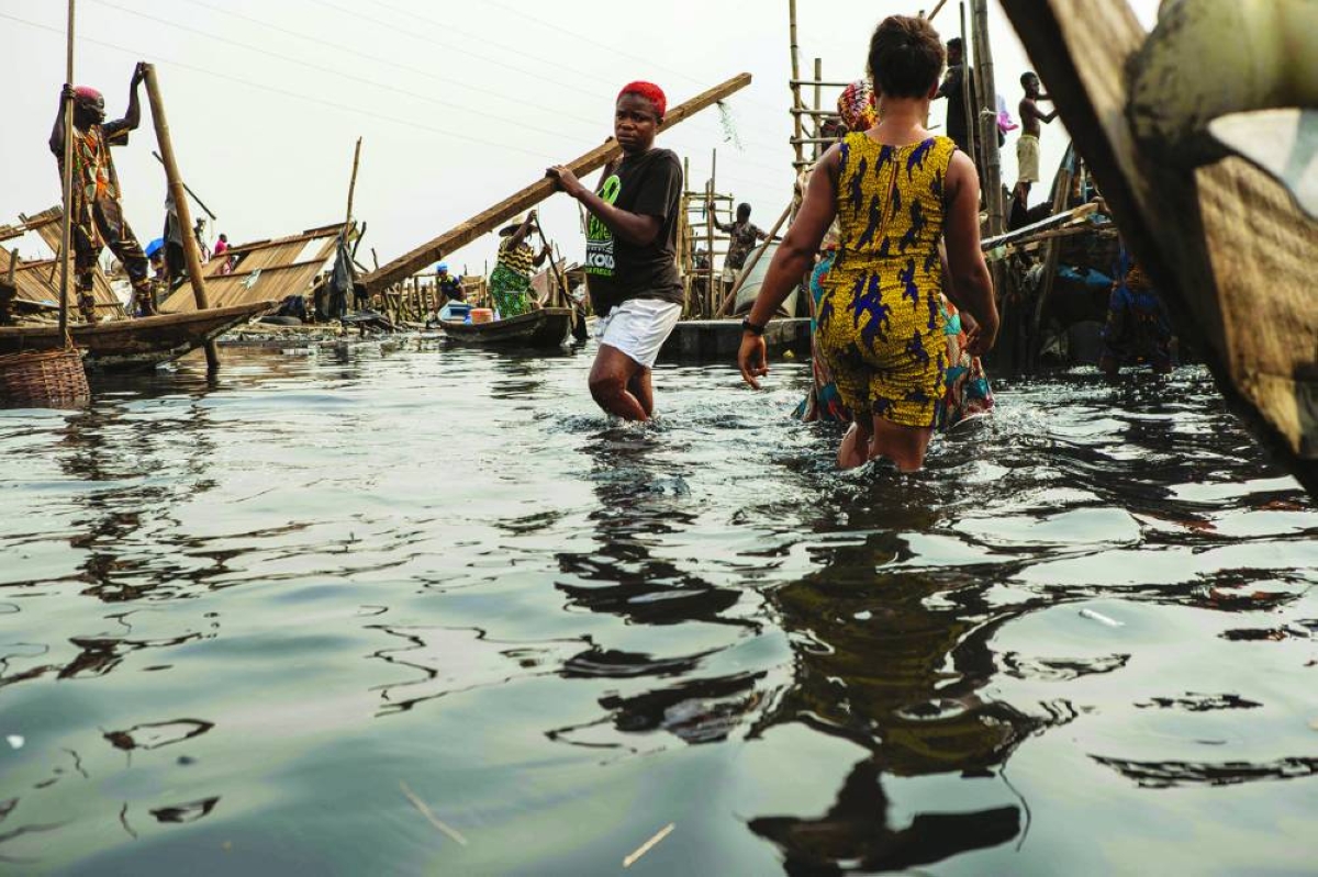 Residents evacuate items following forceful eviction and demolition of homes in Makoko, a floating slum in Lagos, on January 9, 2026. Authorities have demolished hundreds of wooden shacks in Makoko, Africa’s largest and most iconic floating slum, which is built on stilts above the lagoon in the heart of Lagos. The operation is part of an ongoing campaign to remove what officials describe as illegal structures and reclaim waterfront land for modern real-estate developments. (Photo by TOYIN ADEDOKUN / AFP)