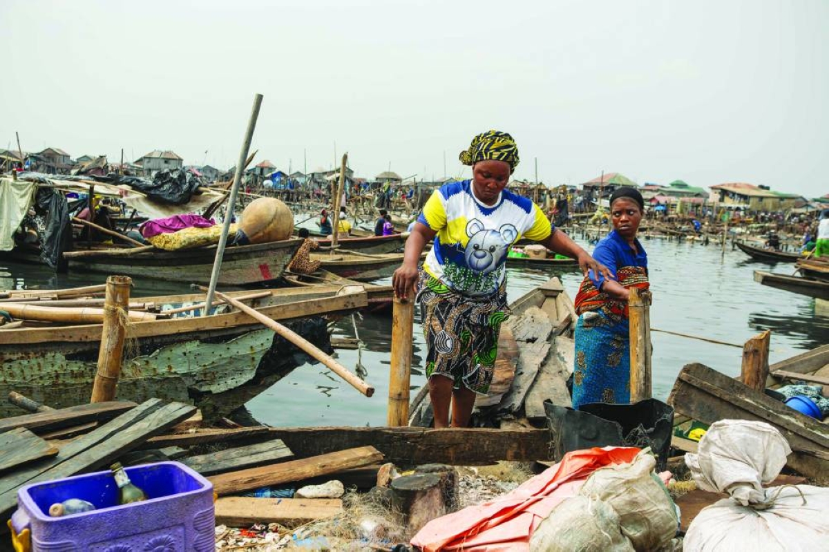 Residents evacuate household wares in a boat following forceful eviction and demolition of homes in Makoko, a floating slum in Lagos, on January 9, 2026. Authorities have demolished hundreds of wooden shacks in Makoko, Africa’s largest and most iconic floating slum, which is built on stilts above the lagoon in the heart of Lagos. The operation is part of an ongoing campaign to remove what officials describe as illegal structures and reclaim waterfront land for modern real-estate developments. (Photo by TOYIN ADEDOKUN / AFP)