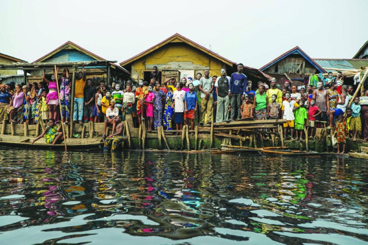 Residents look on during demolition of houses in Makoko, a floating slum in Lagos, on January 9, 2026. Authorities have demolished hundreds of wooden shacks in Makoko, Africa’s largest and most iconic floating slum, which is built on stilts above the lagoon in the heart of Lagos. The operation is part of an ongoing campaign to remove what officials describe as illegal structures and reclaim waterfront land for modern real-estate developments. (Photo by TOYIN ADEDOKUN / AFP)