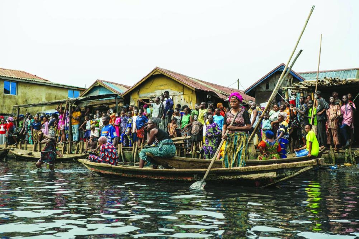 Residents look on during demolition of houses in Makoko, a floating slum in Lagos, on January 9, 2026. Authorities have demolished hundreds of wooden shacks in Makoko, Africa’s largest and most iconic floating slum, which is built on stilts above the lagoon in the heart of Lagos. The operation is part of an ongoing campaign to remove what officials describe as illegal structures and reclaim waterfront land for modern real-estate developments. (Photo by TOYIN ADEDOKUN / AFP)