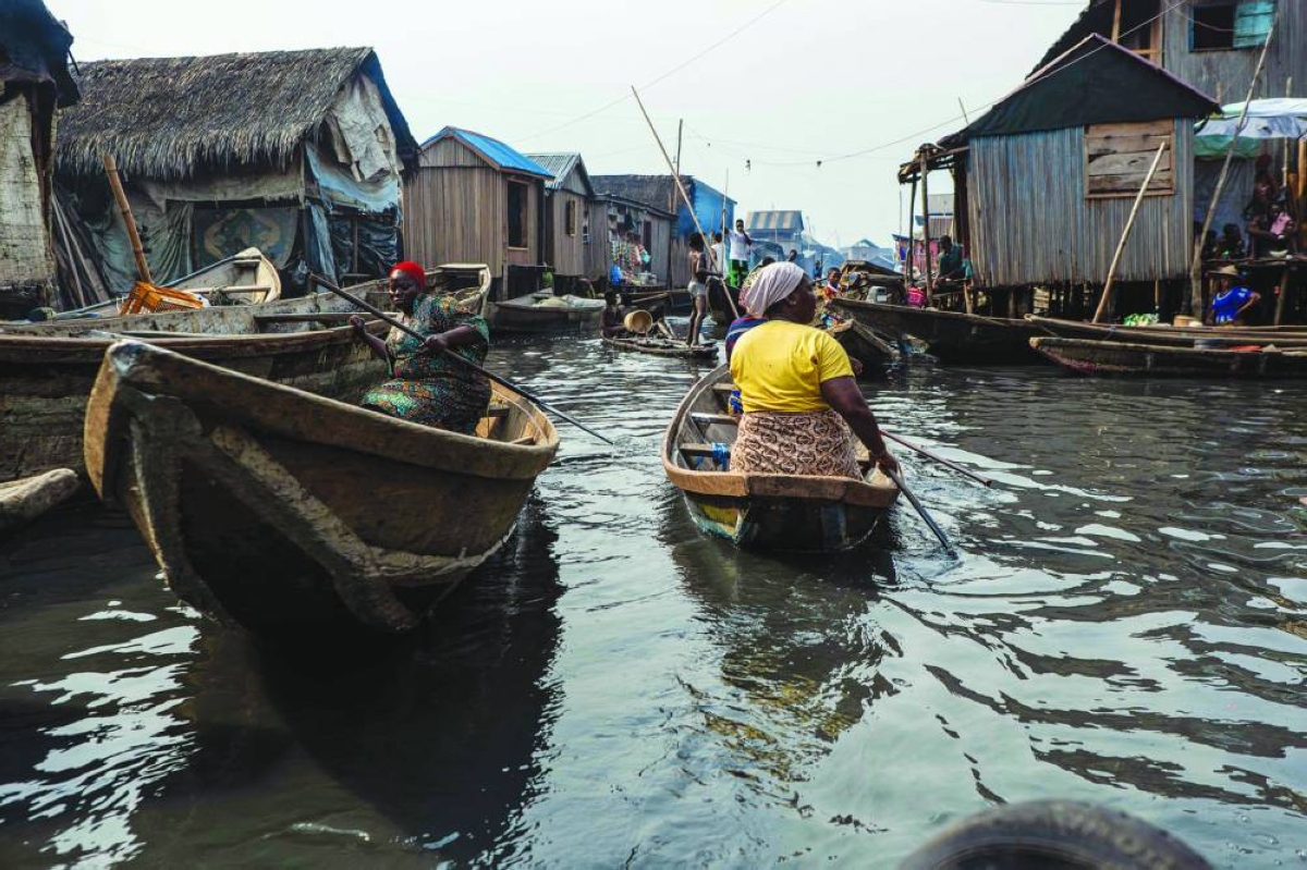 People in pirogues navigate their way in Makoko, a floating slum in Lagos, on January 9, 2026. Authorities have demolished hundreds of wooden shacks in Makoko, Africa’s largest and most iconic floating slum, which is built on stilts above the lagoon in the heart of Lagos. The operation is part of an ongoing campaign to remove what officials describe as illegal structures and reclaim waterfront land for modern real-estate developments. (Photo by TOYIN ADEDOKUN / AFP)