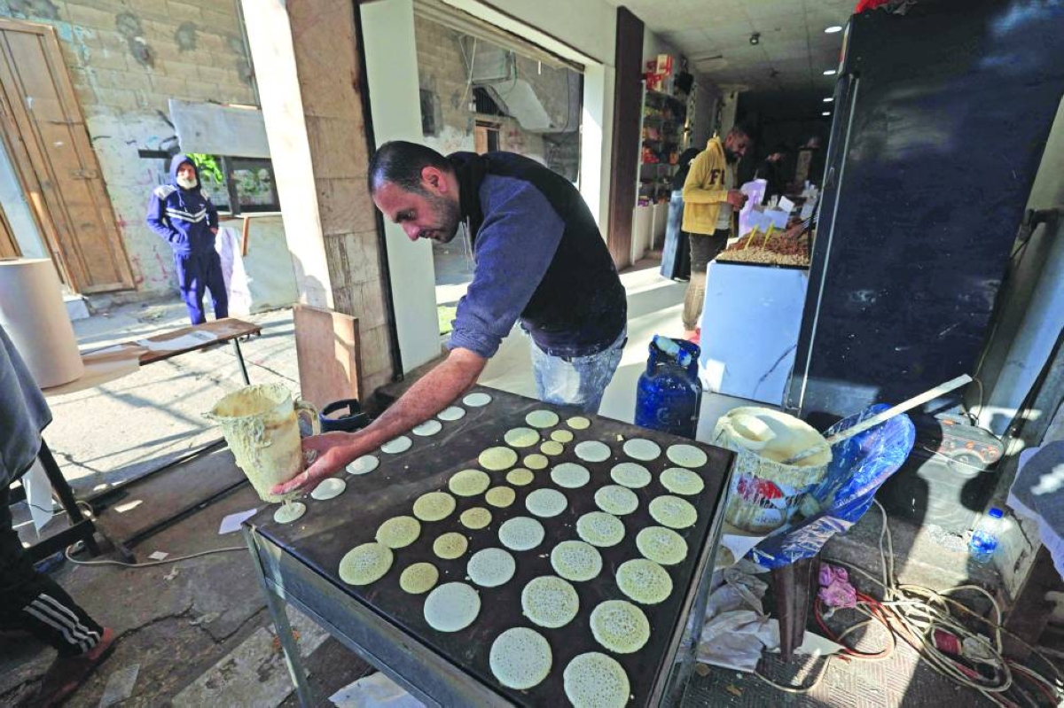 A displaced Palestinian prepares to sell a popular dessert qatayef during the holy month of Ramadan, at a market in an attempt to overcome harsh living conditions in Nuseirat in the central Gaza Strip, on February 20, 2026. (Photo by Eyad Baba / AFP)