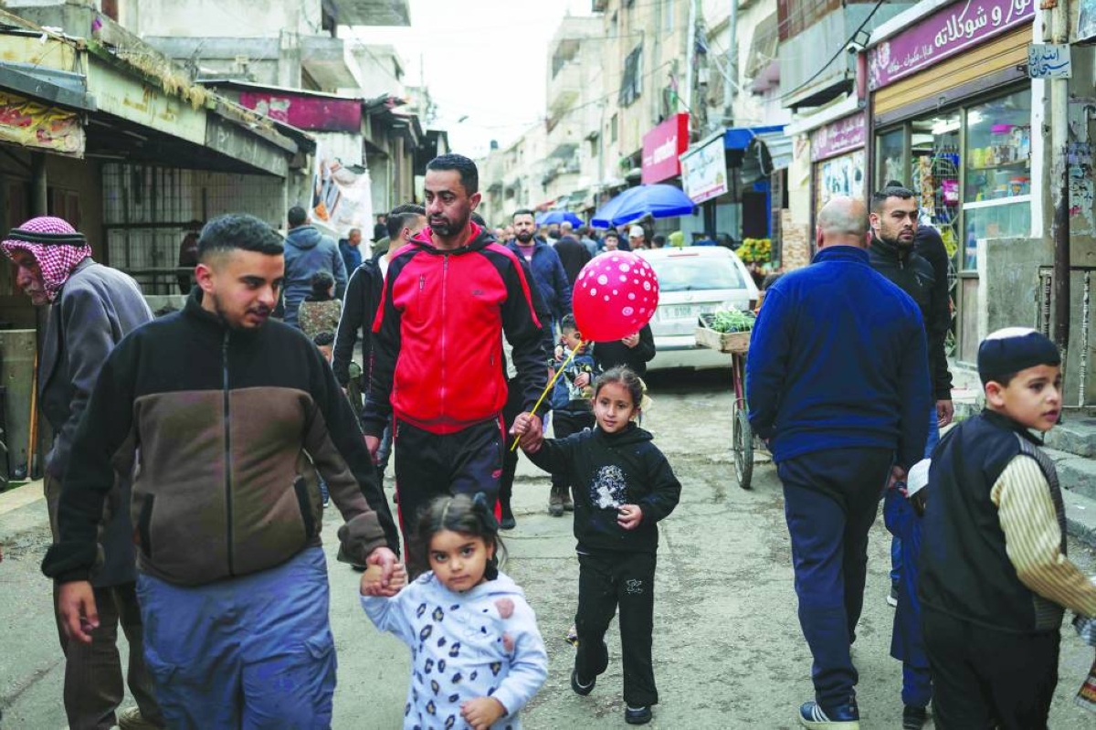 
People walk along a market street during the holy month of Ramadan in the Balata camp for Palestinian refugees, on the eastern outskirts of Nablus in the Israeli-occupied West Bank. 