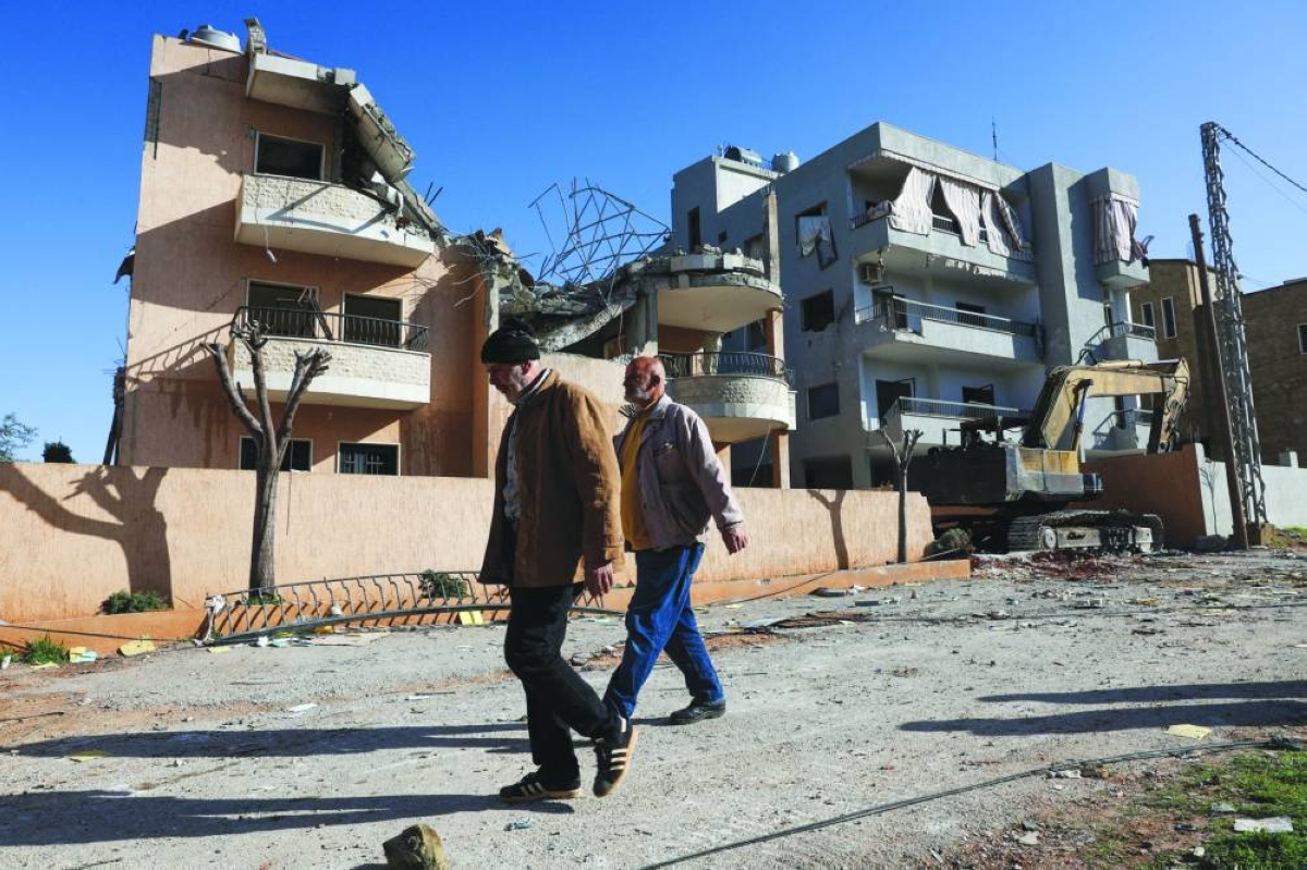 People walk past a damaged building, in the aftermath of an Israeli strike on Friday, in Riyak, Bekaa valley, Lebanon, Saturday.