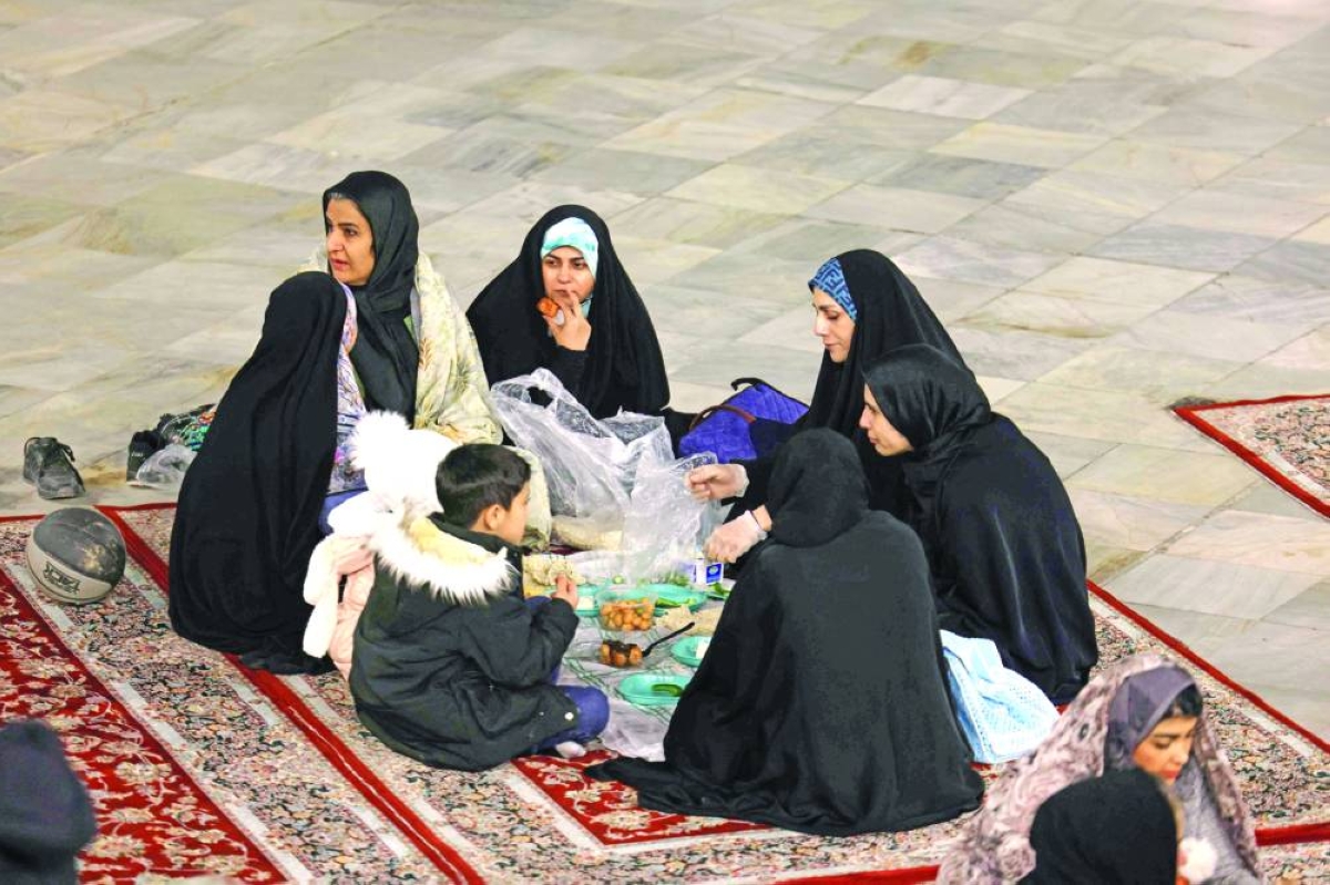 An Iranian family sits together to break the dawn to dusk Ramadan fast during Iftar, in the grounds of the Imamzadeh Saleh mosque in Tehran on February 21, 2026. Muslims throughout the world are marking the month of Ramadan, the holiest month in the Islamic calendar, during which devotees fast from dawn until dusk. (AFP)
