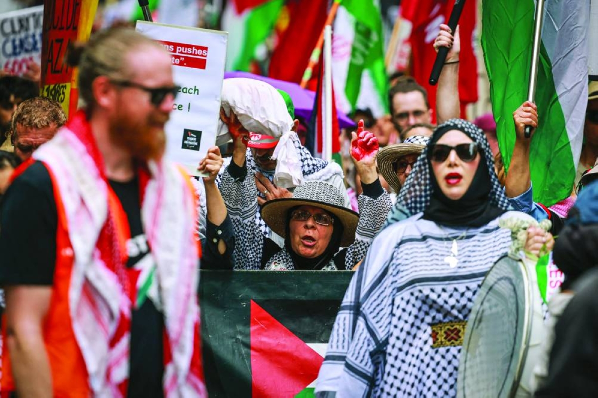 Pro-Palestinian demonstrators hold flags, banners and placards as they march through the streets during a rally in Sydney on February 22, 2026. (AFP)