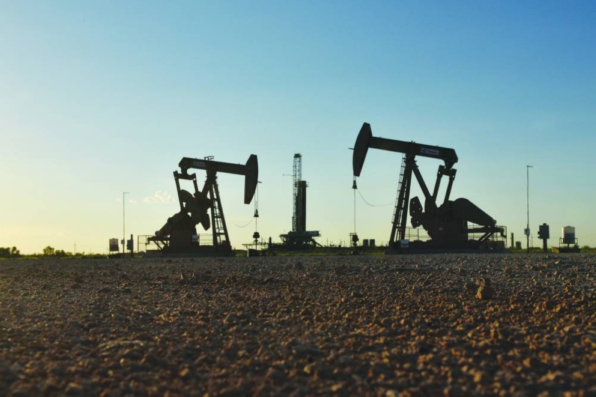 Pump jacks operate in front of a drilling rig in an oil field in Midland, Texas.  A deep freeze in the US contributed to two of the four largest declines in American oil inventories this century. 