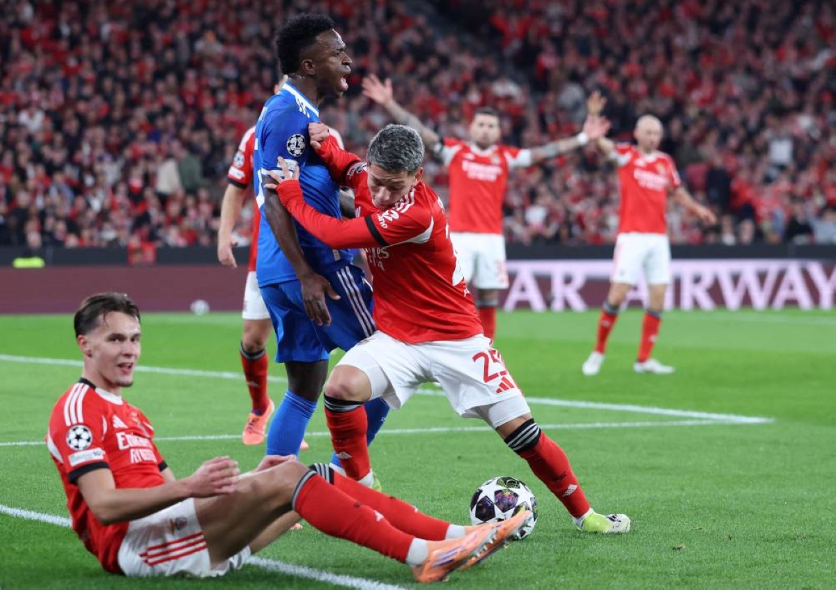 (FILES) Real Madrid's Brazilian forward #07 Vinicius Junior fights for the ball with SL Benfica's Argentine forward #25 Gianluca Prestianni during the UEFA Champions League knockout round play-off first leg football match between SL Benfica and Real Madrid CF at Estadio da Luz in Lisbon on February 17, 2026. UEFA on February 23, 2026 suspended midfielder Gialuca Prestianni from Benfica's Champions League play-off second leg against Real Madrid this week after he was accused of racially abusing Vinicius Junior. (Photo by AFP)