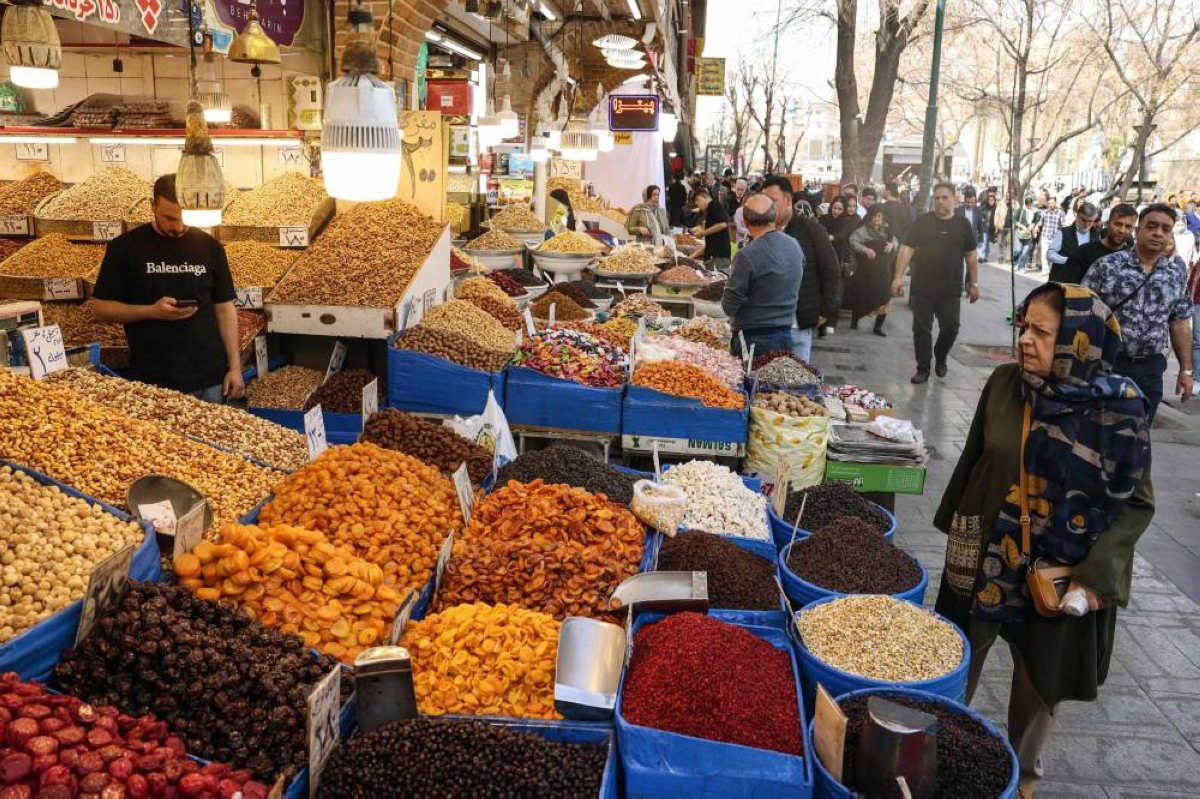 A woman looks at a stall displaying dried fruits and nuts at Tehran's Grand Bazaar on February 24, 2026. Iran warned the United States on February 23, 2026, that any attack would be met "ferociously" in response to the US president's threat of limited strikes. The United States has built up forces in the Middle East to pile pressure on Iran to make a deal at negotiations due to restart on February 26, with the US president weighing a limited strike if no agreement is reached. (Photo by AFP)