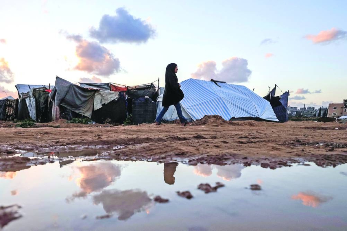 A woman walks through Nuseirat Refugee Camp, north of Dier Al-Balah in the Gaza Strip, Thursday. (AFP)