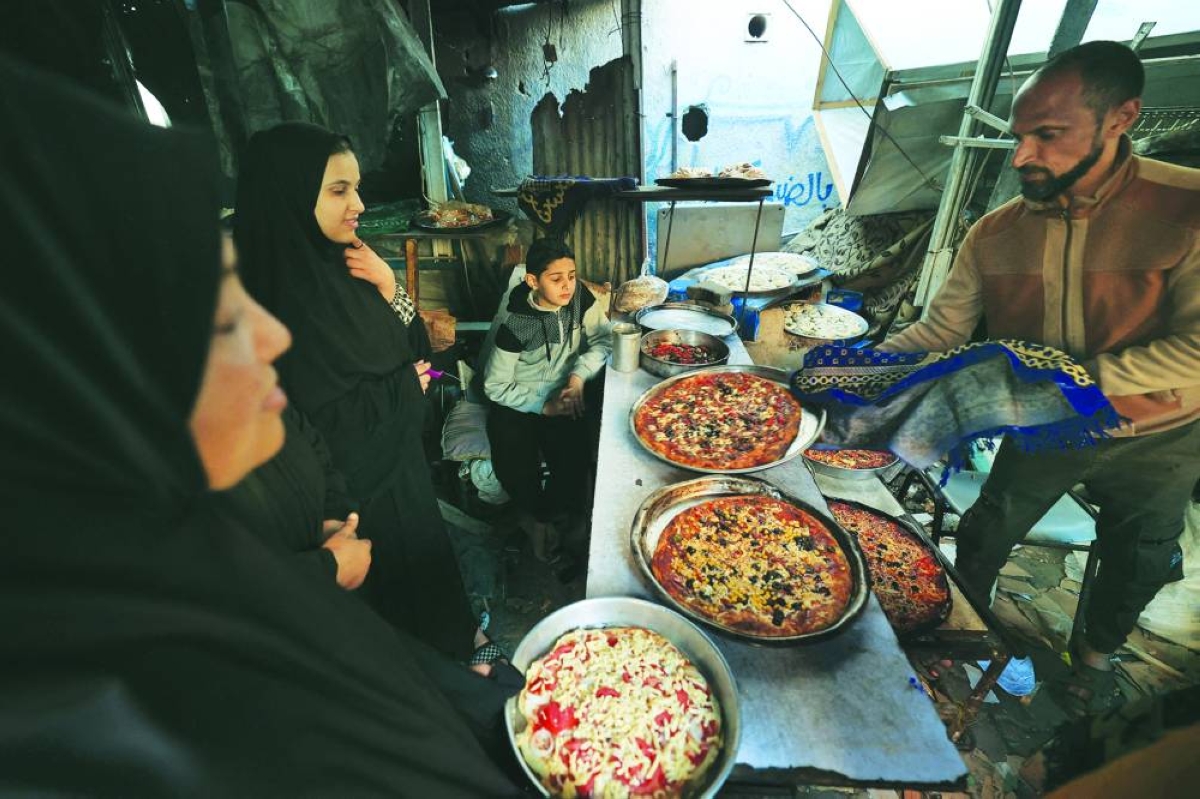 
A displaced Palestinian family prepares Iftar amidst the destruction in Bureij refugee camp in the central Gaza Strip. (AFP) 
