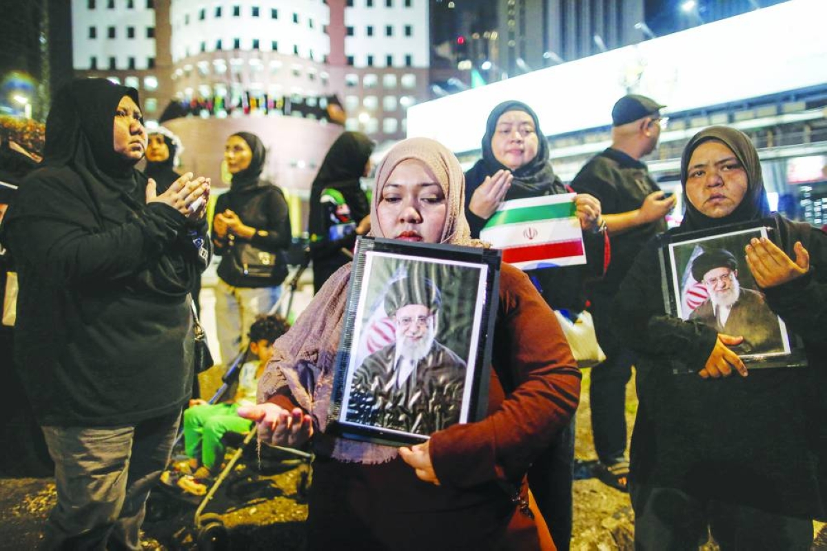 Muslim women holding portraits of Iran's late supreme leader Ayatollah Ali Khamenei gather during a solidarity protest outside of the US embassy in Kuala Lumpur on March 1, 2026 after the death of Iran's supreme leader Khamenei amid US-Israel strikes. (AFP)