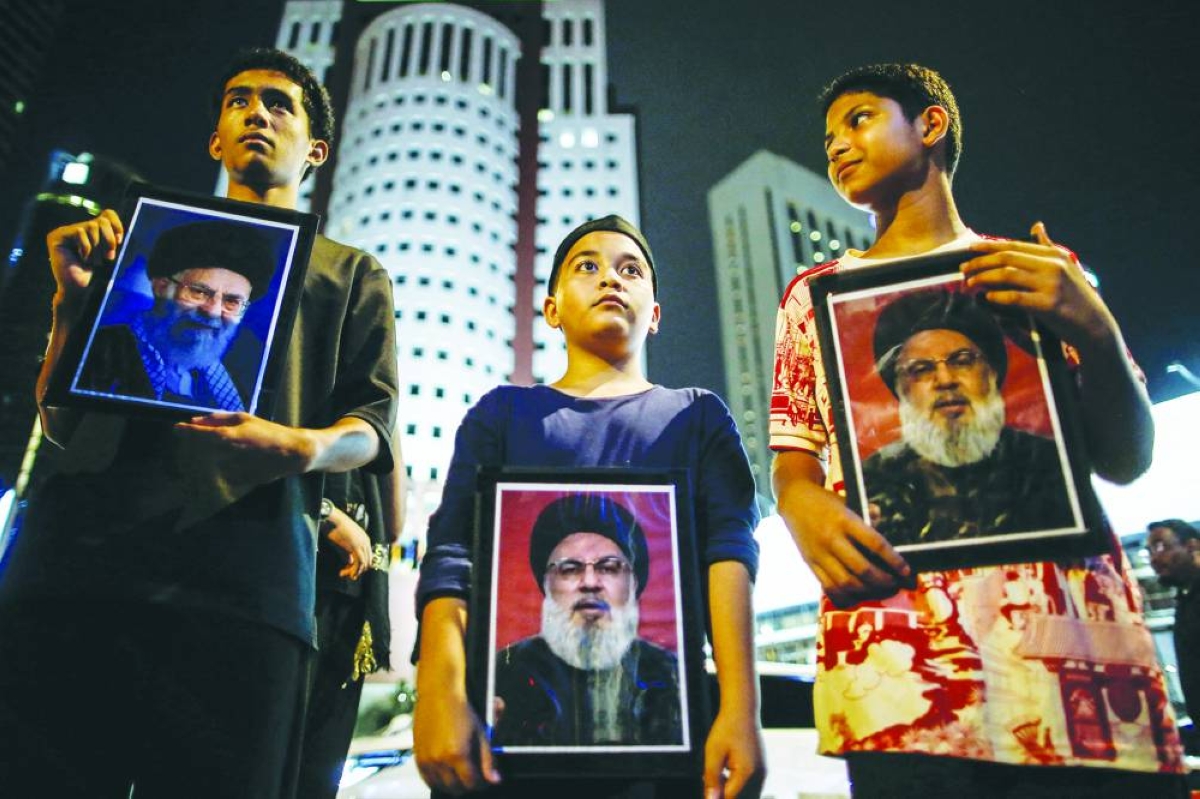 Young boys holding portraits of Iran's late supreme leader Ayatollah Ali Khamenei gather during a solidarity protest outside of the US embassy in Kuala Lumpur on March 1, 2026 after the death of Iran's supreme leader Khamenei amid US-Israel strikes. (AFP)