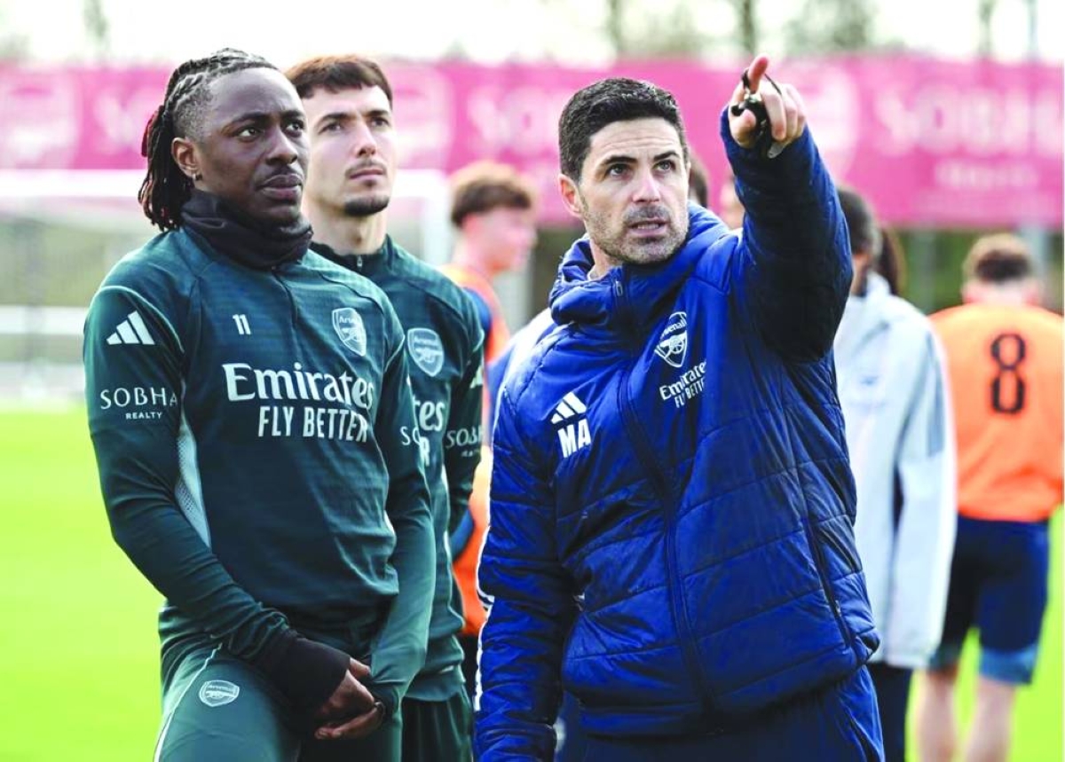 Arsenal manager Mikel Arteta (right) with midfielders Eberechi Eze and Martín Zubimendi during a training session.