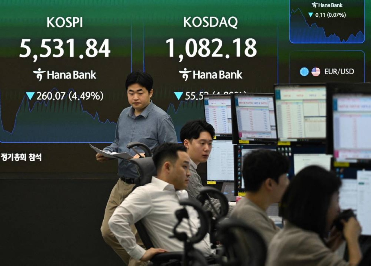 Currency dealers monitor exchange rates as an electronic screen shows South Korea's benchmark stock index (KOSPI) and the Korean Securities Dealers Automated Quotations (KOSDAQ) in a foreign exchange dealing room at the Hana Bank headquarters in Seoul on March 4, 2026. Asian stocks plunged in early trade on March 4, as the ongoing turmoil in the Middle East rattled global markets. (Photo by Jung Yeon-je / AFP)