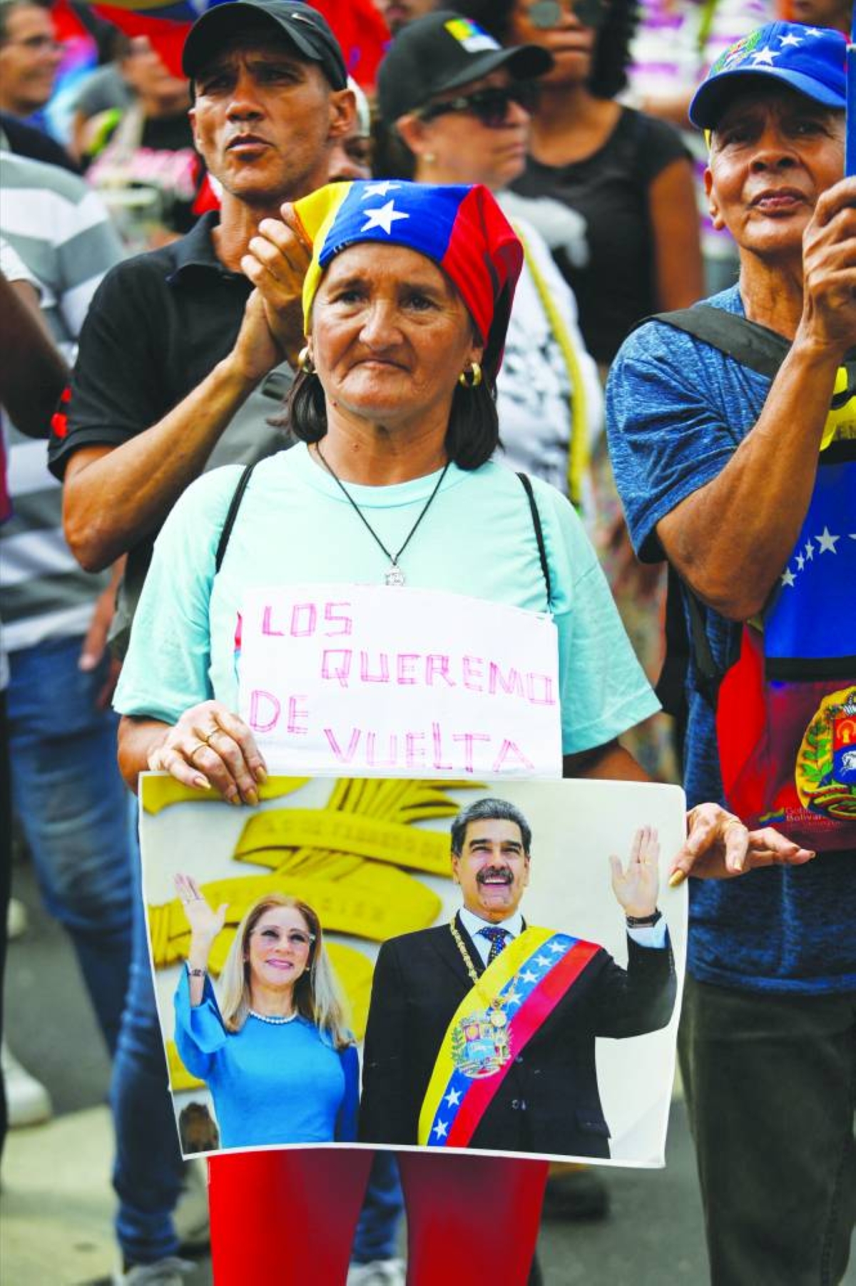 A woman holds a sign reading "We want them back" next to a photo of ousted President Nicolas Maduro and his wife, Cilia Flores, during a demonstration demanding their return, two months after their capture by the United States, in Caracas, Venezuela, March 3, 2026. REUTERS