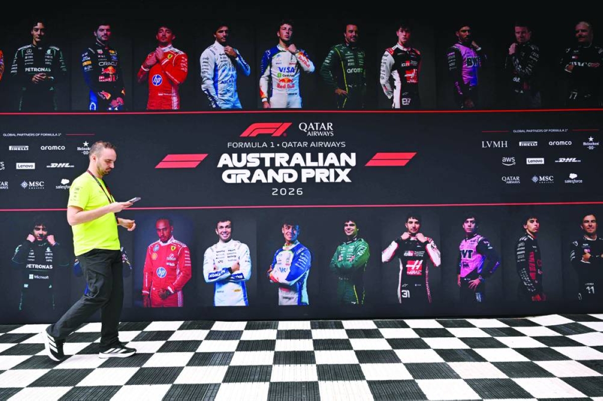 
A crew member walks past images of drivers as teams prepare for the Australian Formula One Grand Prix at the Albert Park Circuit in Melbourne. (AFP) 