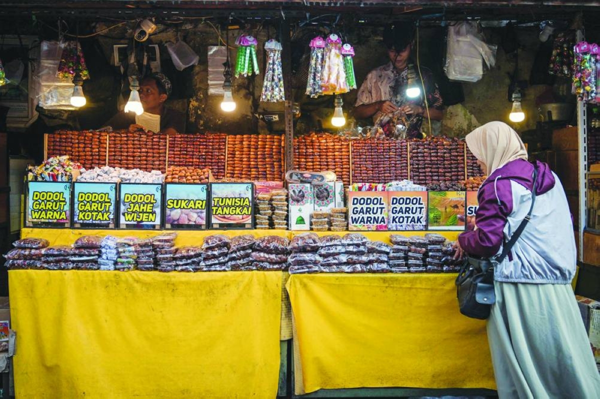 A woman buys dates near the Sunan Ampel Mosque during the holy fasting month of Ramadan in Surabaya, Indonesia's East Java province on March 8, 2026. (AFP)