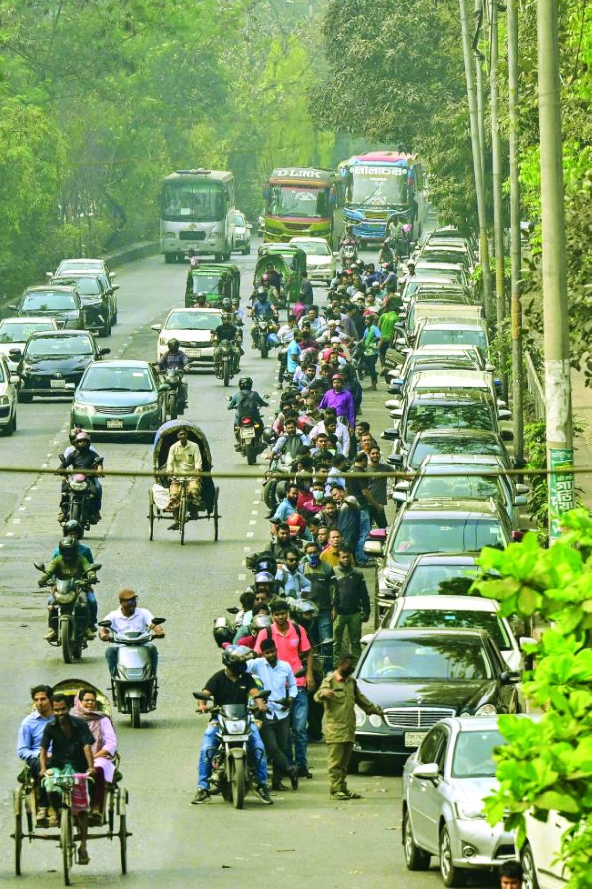 People wait in a queue to refuel their vehicles near a fuel station in Dhaka Monday. (AFP)