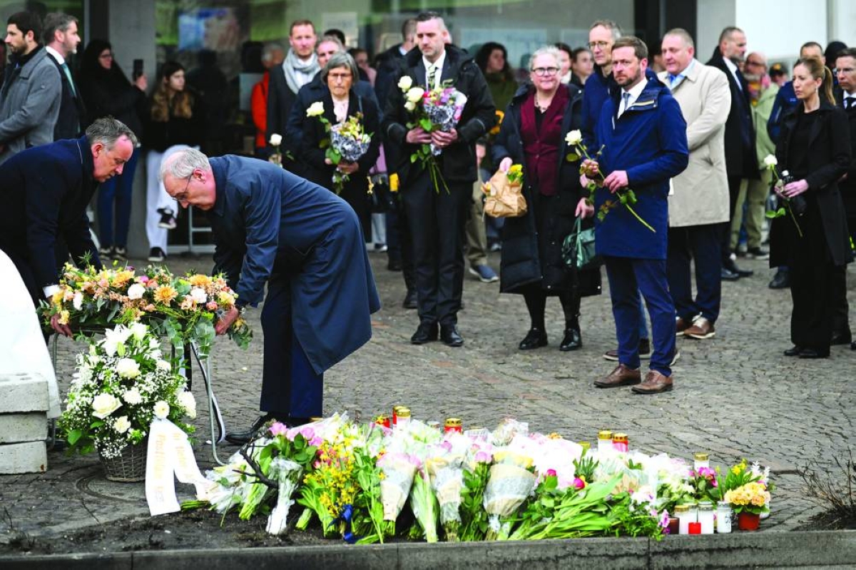 Swiss President Guy Parmelin lies flowers in tribute at the site of a deadly bus fire in Kerzers, Switzerland, Wednesday. (Reuters)