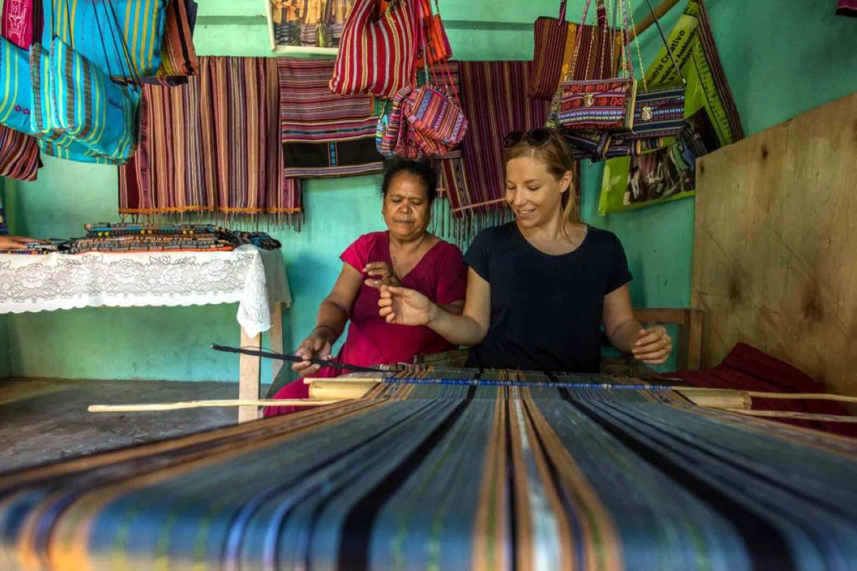 A tourist experiences traditional tais textile weaving, one of Timor-Leste’s cultural crafts