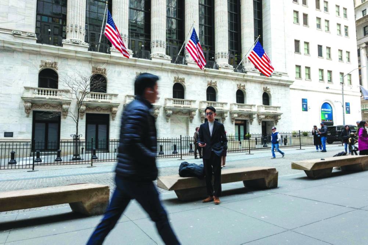 People walk outside of the New York Stock Exchange. Investors will seek clarity in the coming week on how much the Middle East conflict is complicating expectations for ‌interest-rate cuts this year, as they brace for developments in the Iran war that could rattle markets.