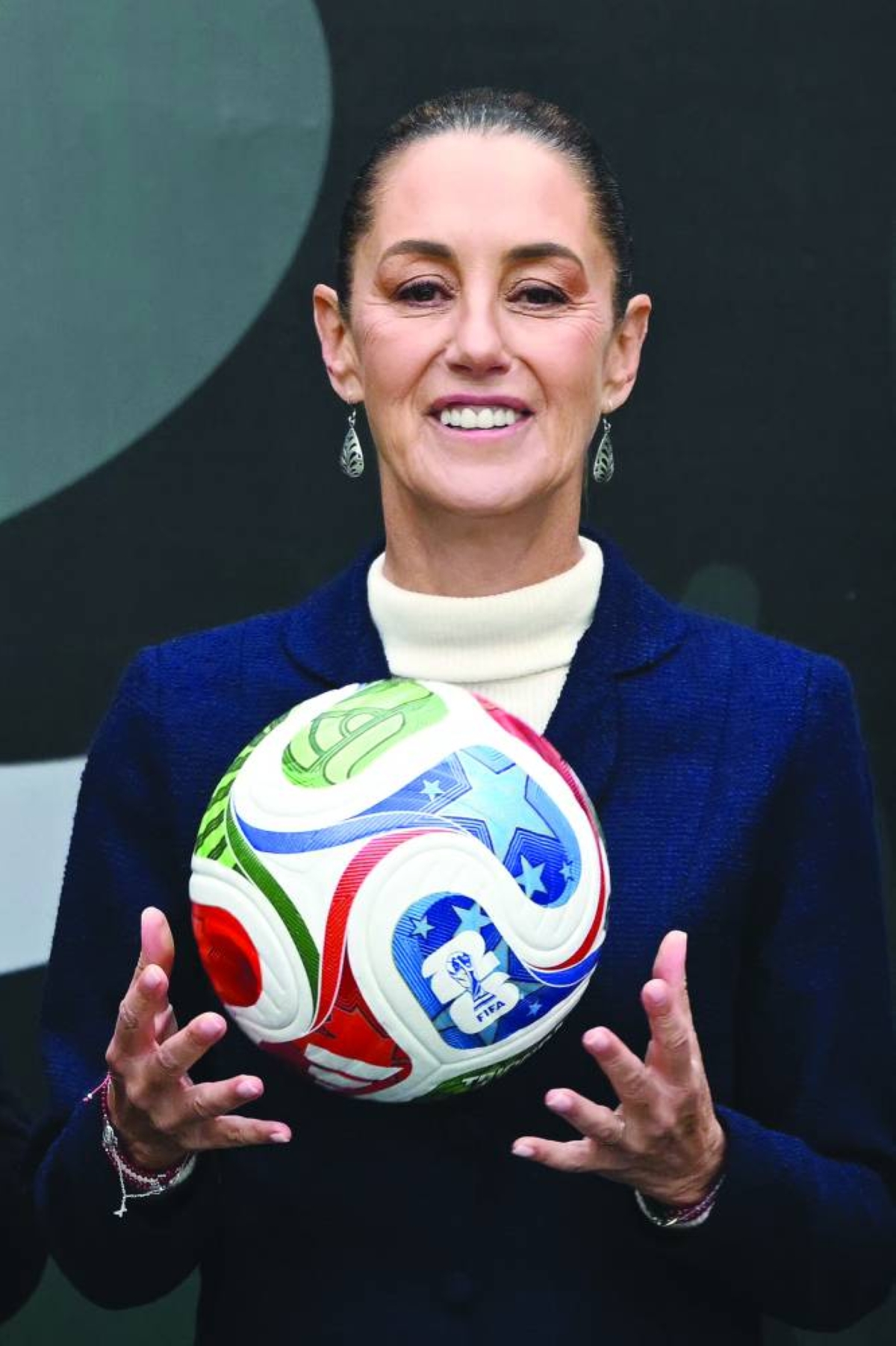 (FILE PICTURE) Mexican President Claudia Sheinbaum holds a FIFA Wold Cup 2026 official ball during a FIFA World Cup 2026 organization plan presentation in Mexico City, on November 10, 2025. Mexican President Claudia Sheinbaum confirmed on March 17, 2026, that her country was prepared to host Iran's first-round matches at the 2026 World Cup if needed due to the conflict in the Middle East. (AFP)