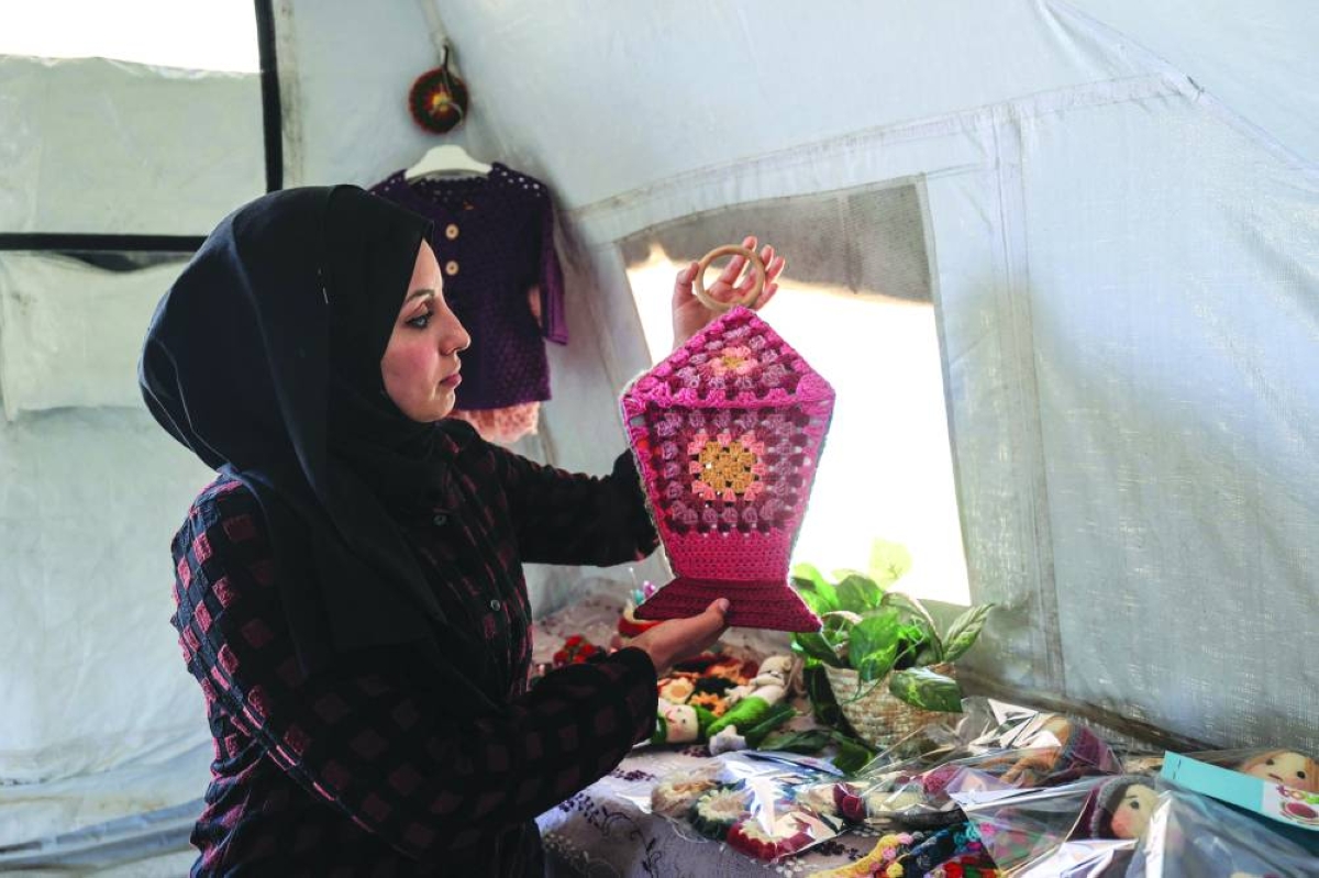 Displaced Palestinian Shireen al-Kurdi displays in her tent the crochet dolls and decorations she made to sell for the Eid al-Fitr holiday, which marks the end of the holy month of Ramadan, at the Bureij refugee camp in the central Gaza Strip, Tuesday.(AFP)