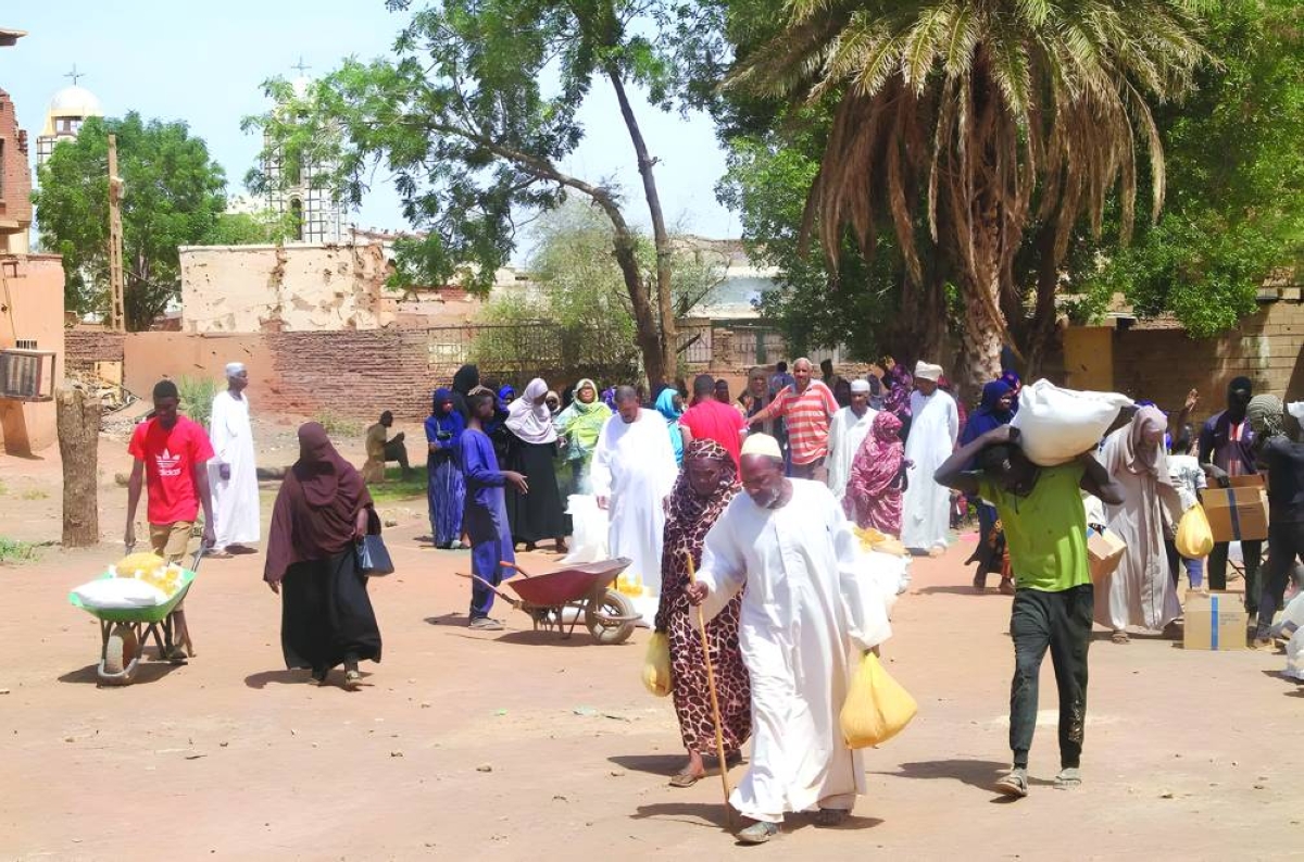 Residents receive aid from World Food Program (WFP) at Al-Omada neighborhood of Omdurman, the twin city of Khartoum on March 11, 2026. (AFP) 