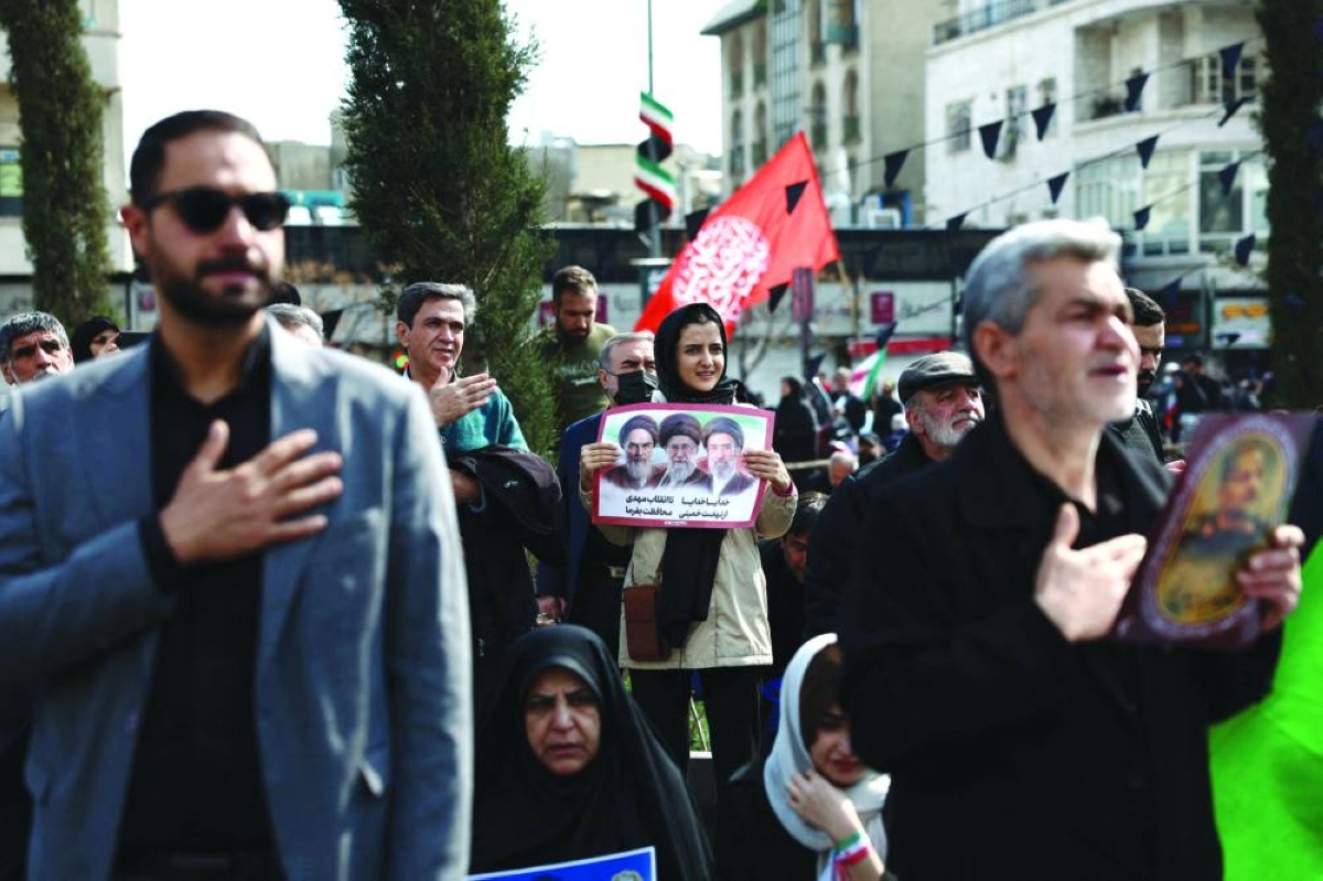 People gather for the funeral of Iranian security chief Ali Larijani and victims of the IRIS Dena warship at Enghelab Square, amid the US-Israeli conflict with Iran, in Tehran, Wednesday. (Reuters)