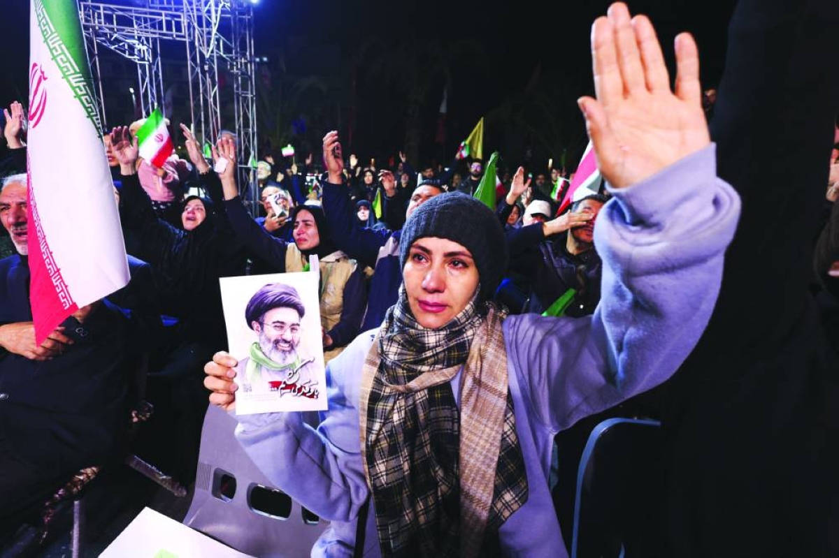 A woman holds a poster of Iran's new Supreme Leader, Mojtaba Khamenei, during an anti-US and anti-Israel rally at Valiasr Square, in Tehran, Iran, March 17, 2026. REUTERS