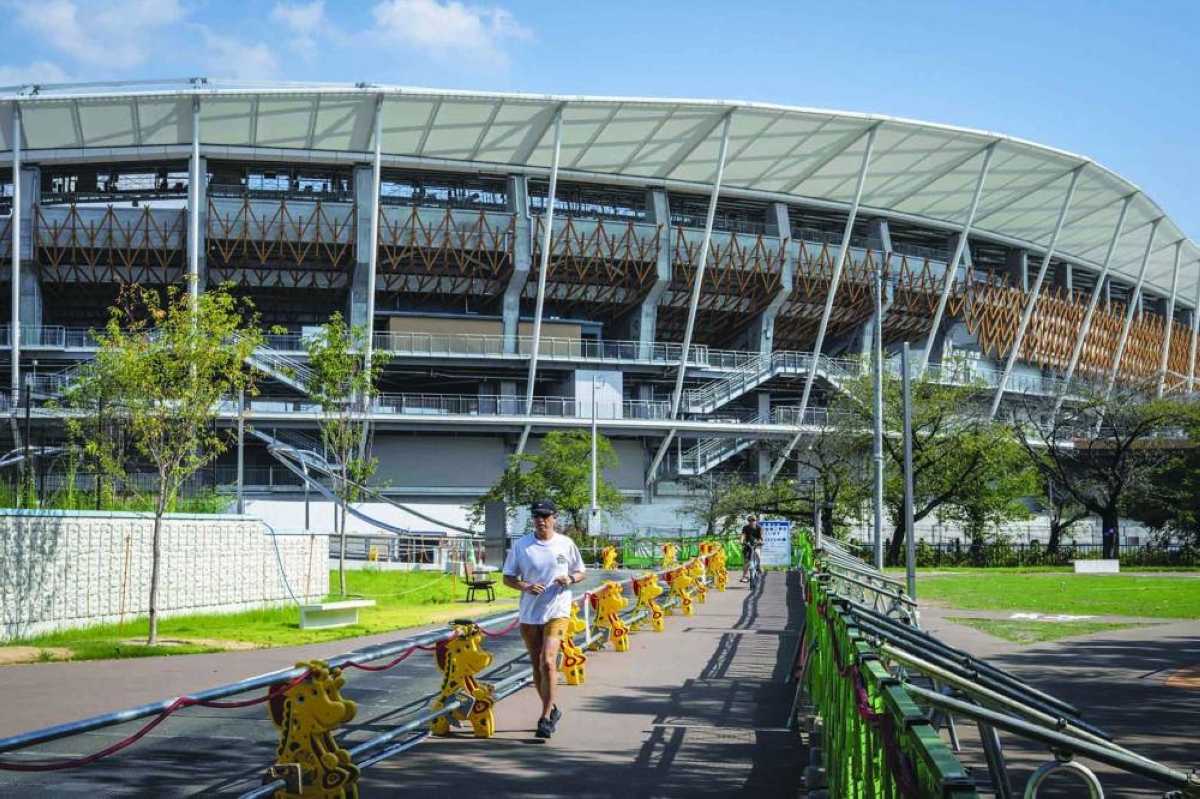 (FILES) This picture taken on September 7, 2025 shows a man jogging past the Nagoya City Mizuho Park Athletic Stadium, the venue for track and field and marathon competitions, at the 2026 Aichi-Nagoya Asian Games in Nagoya, Aichi prefecture. Athletes at the Asian Games in Japan will enjoy "a unique experience" staying on a cruise ship and in wooden containers, an organising official told AFP, but acknowledged there were concerns about the plan. (AFP) 